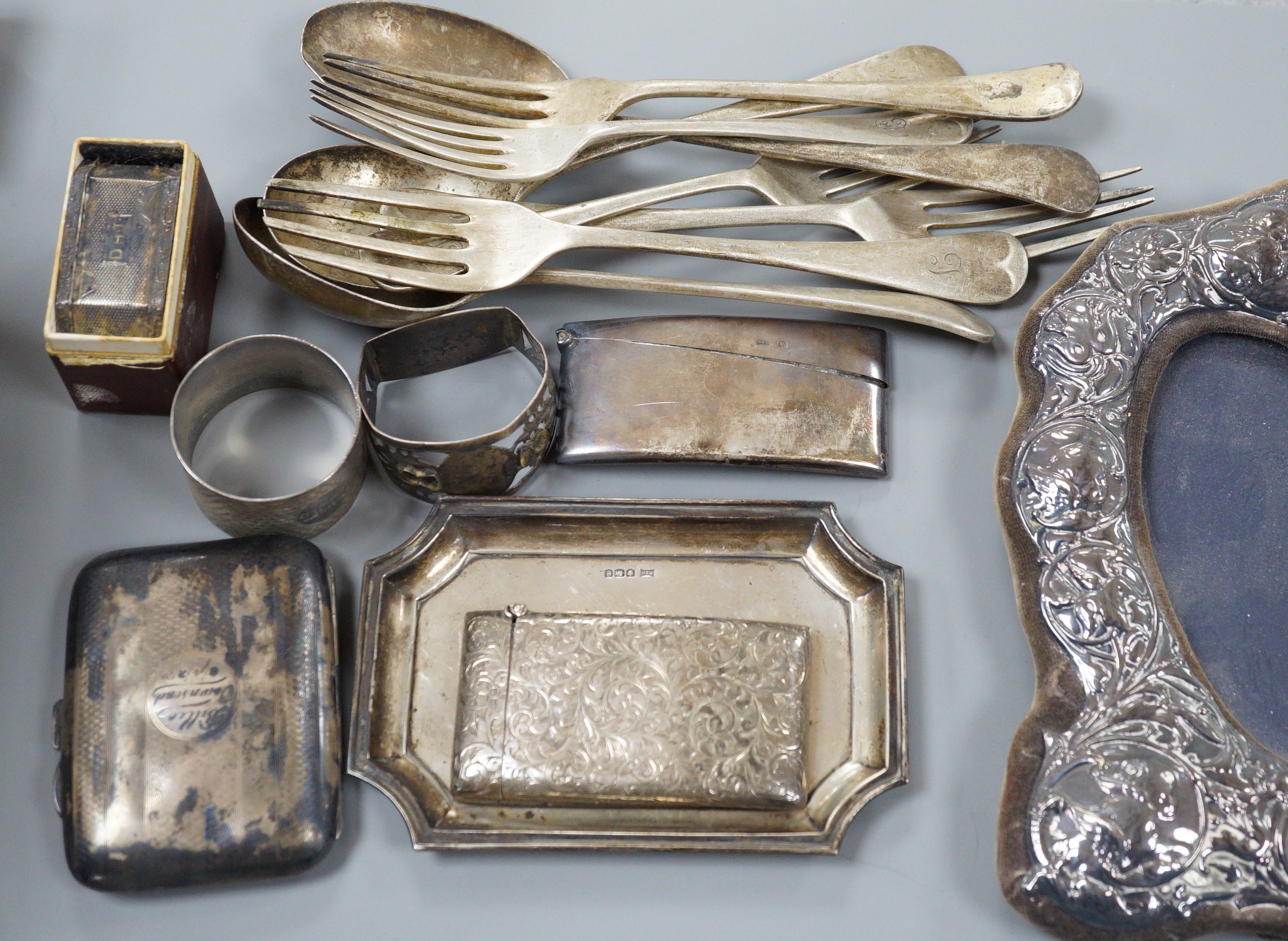 A mixed collection of silver to include cutlery, napkin rings, photograph frame, card cases, small dish, etc.